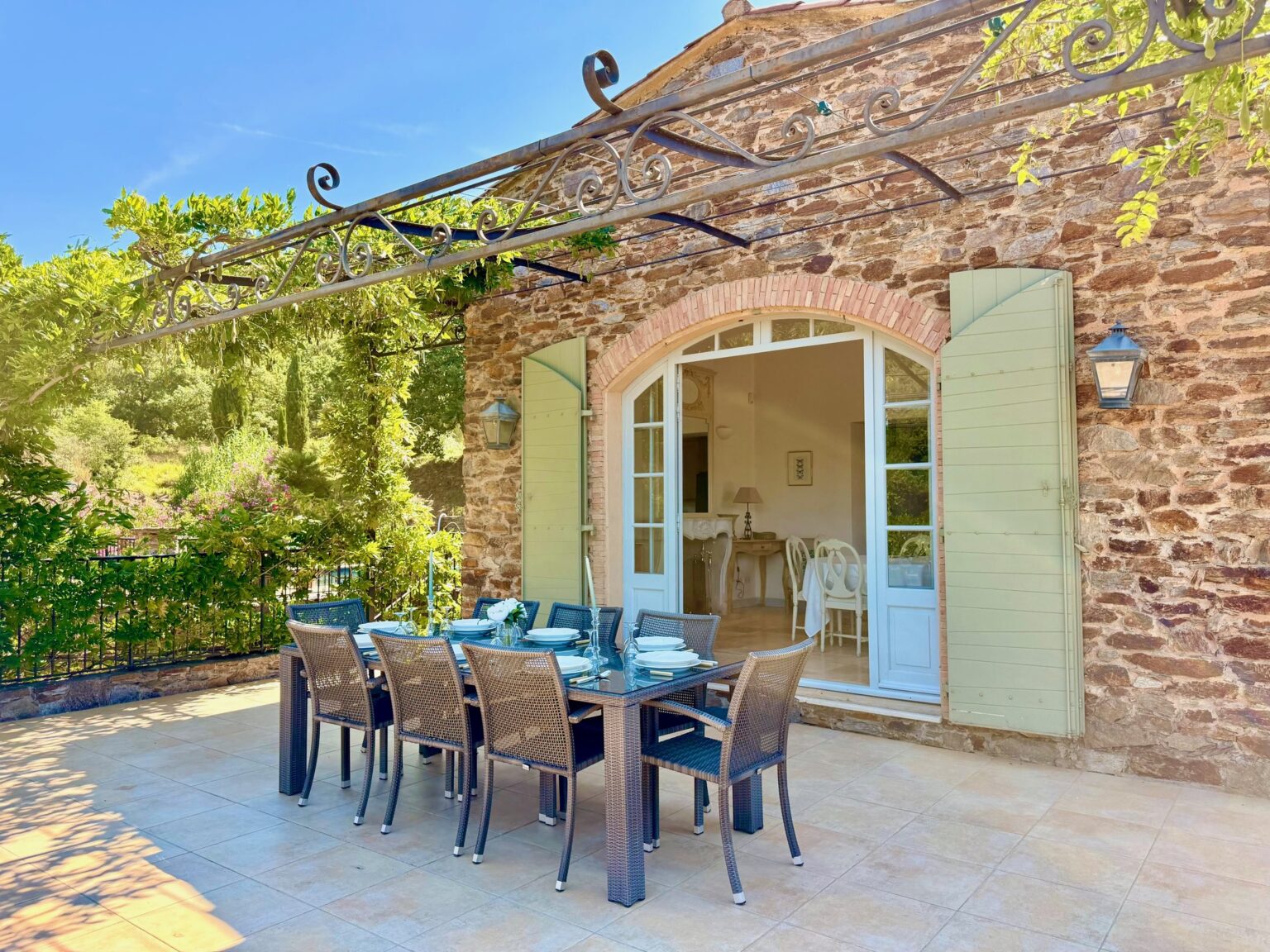 La terrasse en pierre et les volets ouverts du Petit Verger